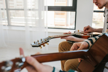 Wall Mural - Learning to play the guitar. Music education and extracurricular lessons.