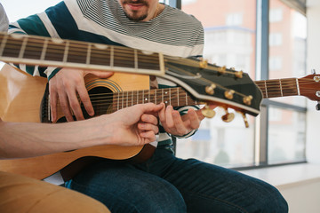 Wall Mural - Learning to play the guitar. Music education and extracurricular lessons.