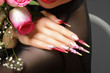 Girl with a bouquet of roses. Female manicure and long nails.