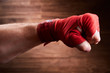 © Aleksey - Close up image of fist of a boxer with red bandage against brown background.