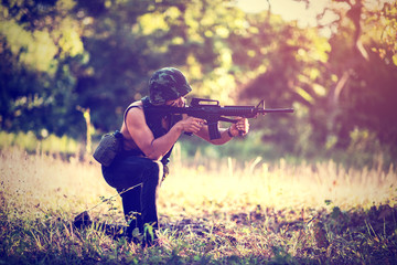 Squad of Israel army combat soldiers firing an assault rifle. Infantry soldiers firing at terror targets. Warrior shooting in prone position during military training in forest landscape.