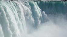 SLOW MOTION, CLOSE UP: Powerful Raging Whitewater Waterfall Falling Forcefully Over A Rocky Edge. Crystal Clear Glacier Water Stream Dropping Over The Cliff. Misty Majestic Niagara Falls River Rapids