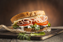 Tasty Sandwich With Ham, Cheese, Tomato And Lettuce On Wooden Background
