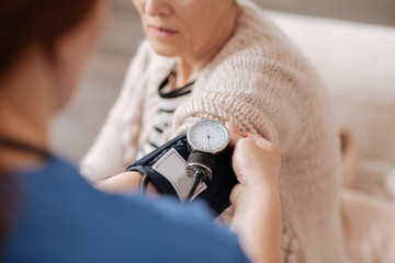 Wall Mural - Delicate competent doctor reading ladies blood pressure