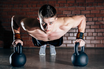 Wall Mural - Sport. Young athletic man doing push-ups. Muscular and strong guy exercising.