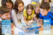 © Syda Productions - group of kids with teacher and tablet pc at school