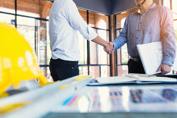 two construction engineers shake hands in construction site