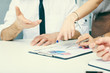© cameravit - Group of business people looking at the clipboard with graphics.