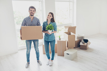 Poster - New life, new start, new home for a young family. What a joy! Happy cheerful lovers are unpacking in a new apartment, standing in a casual wear