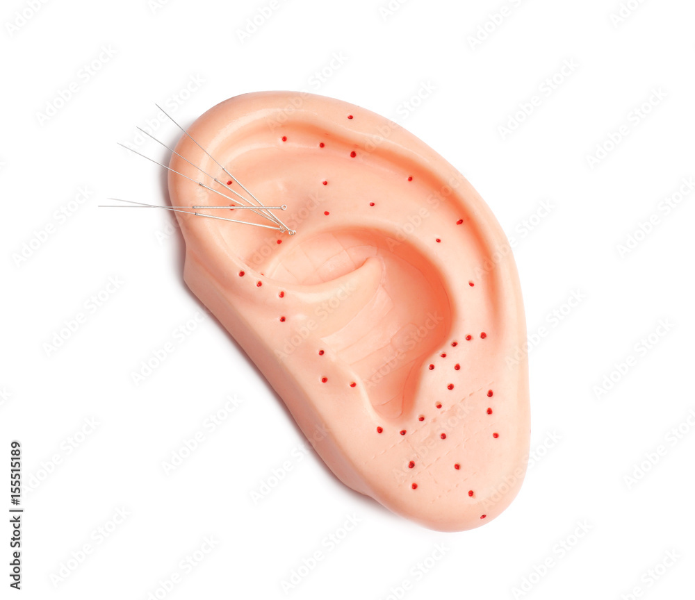 Needles for acupuncture and plastic mockup of human ear on white background