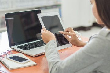 Wall Mural - Beautiful business working woman using Ipad while working with laptop