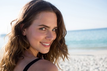 Portrait of smiling young woman with brown hair at beach