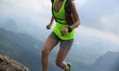 © lzf - Young fitness woman trail runner running at mountain top