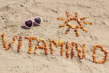 Sunglasses, inscription vitamin D and shape of sun at beach, concept of summer time and healthy lifestyle