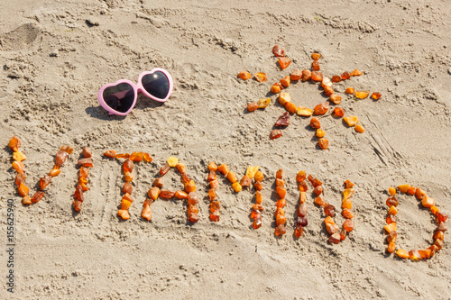 Fotografie, Obraz Sunglasses, inscription vitamin D and shape of sun at beach, concept of summer t