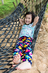 Wall Mural - Cheerful child enjoying and relaxing in hammock, outdoor on summer day.