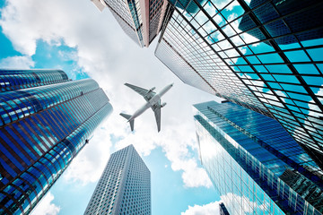 airplane flying over business skyscrapers