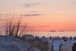 © HERREPIXX - abendstimmung in den dünen am strand von Warnemünde in orange pink mit strandkörben und frachtschiffen am horizont