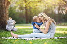 Delighted Mother With Her Son Outdoors In A Park
