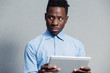 African man embarrassed looking to screen of the tablet PC