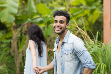 Wall Mural - young couple hispanic man and woman walking tropical forest holiday happy smiling summer vacation tr