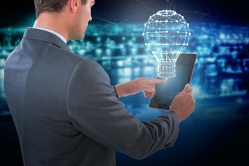 Poster - Composite image of businessman using tablet