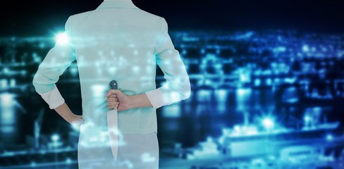 Poster - Composite image of rear view of businesswoman hiding knife