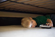© Image Source RF - Boy hiding under bed