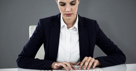 Poster - Composite image of businesswoman typing on keyboard at desk