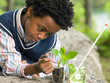 © Image Source RF - A boy doing an experiment on a plant