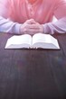 Man with bible praying at table