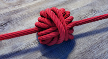 Großer Knoten In Rotem Seil Auf Holz