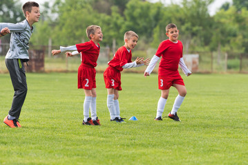 Wall Mural - Kids soccer football - children players match on soccer field