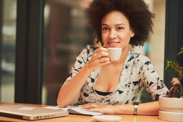 Wall Mural - Mixed race girl drinking coffee while standing at the bar