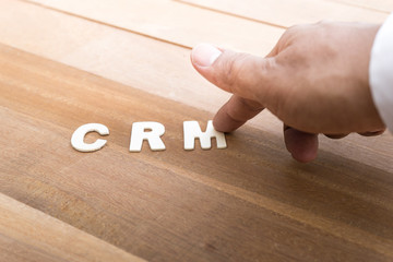 Wall Mural - CRM word with male hand on wood table.Business marketing,analysis concepts word with male hand on wood table.Business marketing,analysis concept