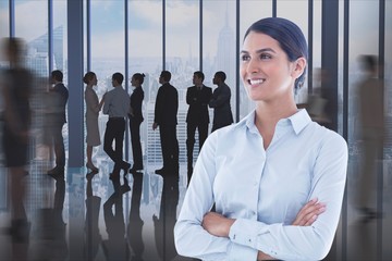 Poster - Businesswoman with crossed arms against office background