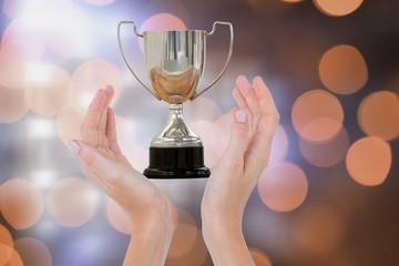 Poster - Hands holding trophy against orange glowing background