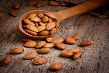 Wall Mural - Almonds on textured wooden background. Peeled nuts. Organic food.