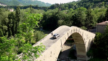 Poster - wan walking on steep ramp of ancient Renaissance bridge while small car is passing