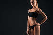 © master1305 - Muscular young woman athlete on black