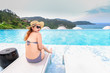 Woman in bikini is sitting on the sundeck on the swimming pool