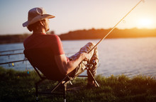 Men Fishing In Sunset And Relaxing While Enjoying Hobby