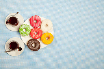 Wall Mural - Two cups of tea and donuts on a blue table