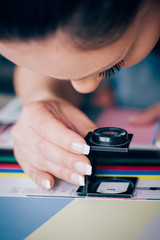 Wall Mural - Worker in printing and press centar uses a magnifying glass