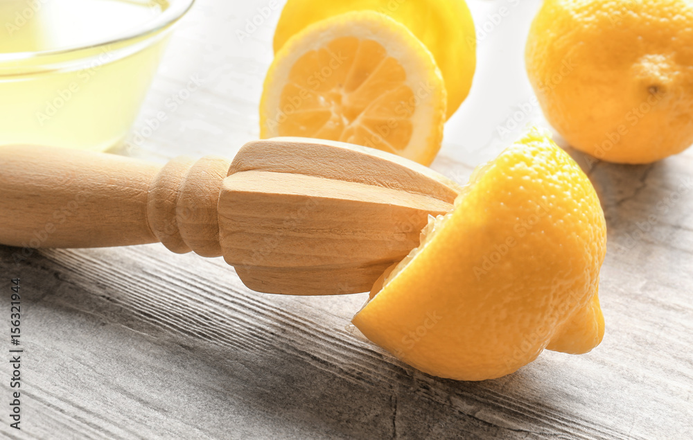 Squeezer and lemons on wooden table