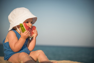 Watermelon and baby girl on beach with copy space