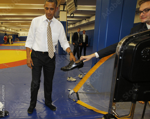 U S President Obama Is Handed His Shoes To Put Back On After