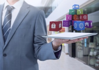 Poster - Businessman holding tablet with apps in shopping mall
