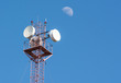 Radio antenna tower over blue sky and moon