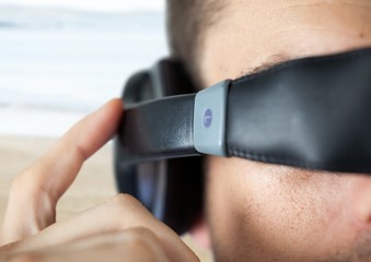 Poster - Close up of VR headset on man against blurry beach